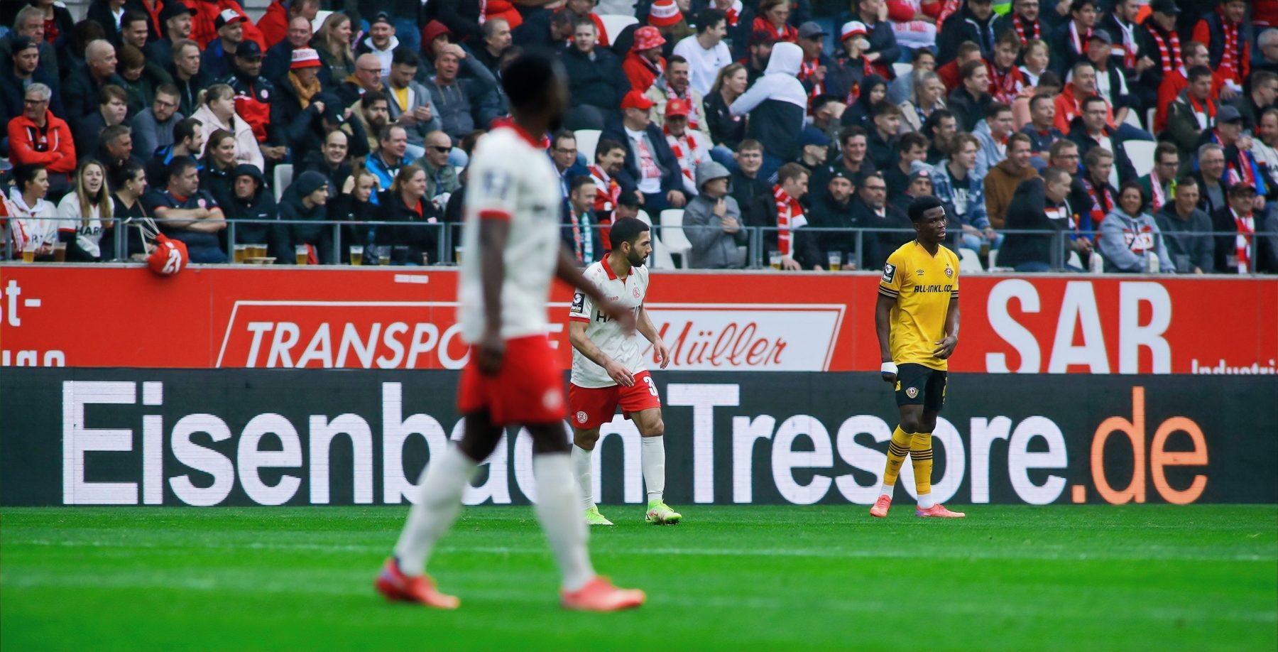 Spielszene vor einer Werbebande im Stadion
