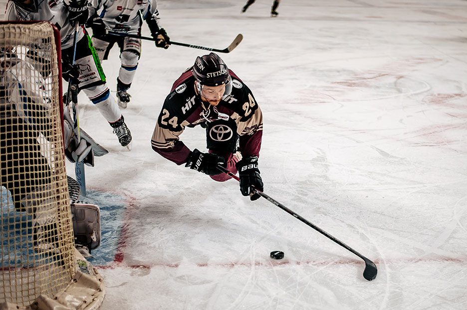 Eishockeyspieler mit Puck vor dem Tor